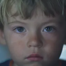 a child with blonde hair in bowl cut