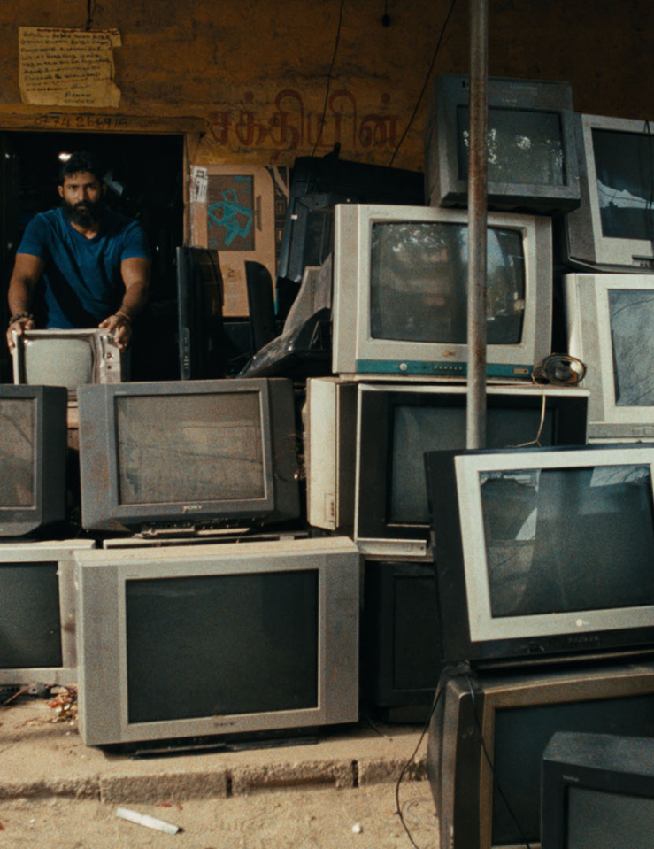 A man stands in a room full of old TV screens.