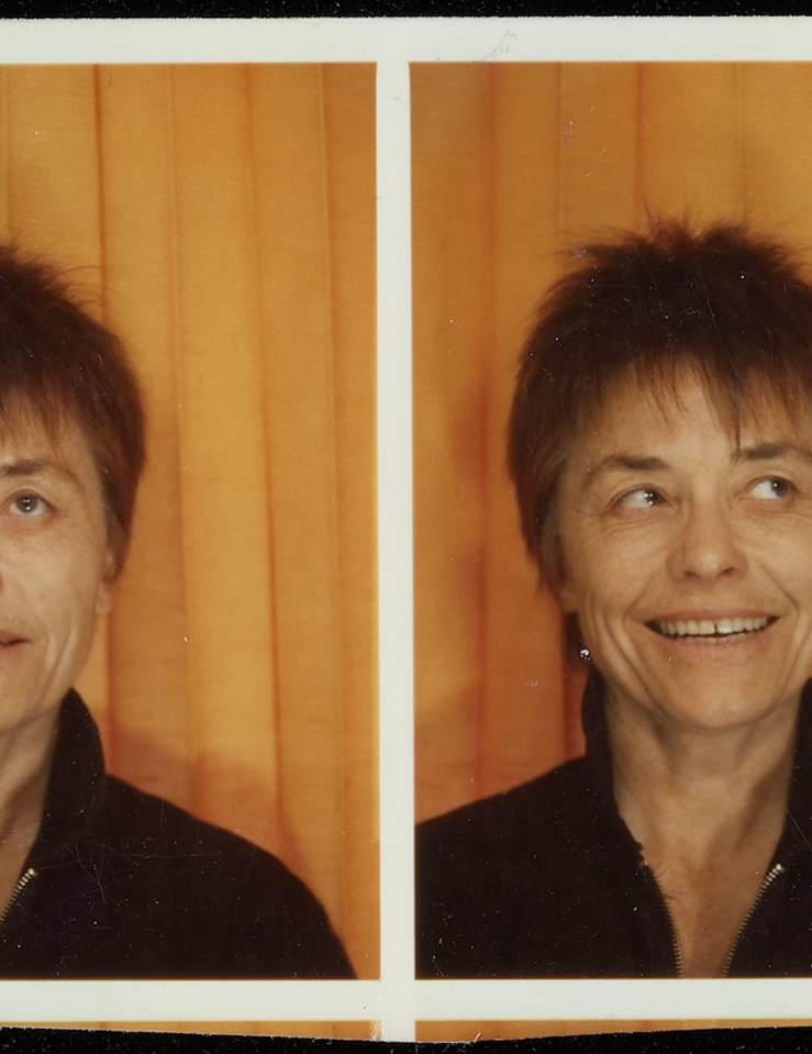Two printed photos of a middle-aged white woman with short spiky auburn hair making two different expressions 